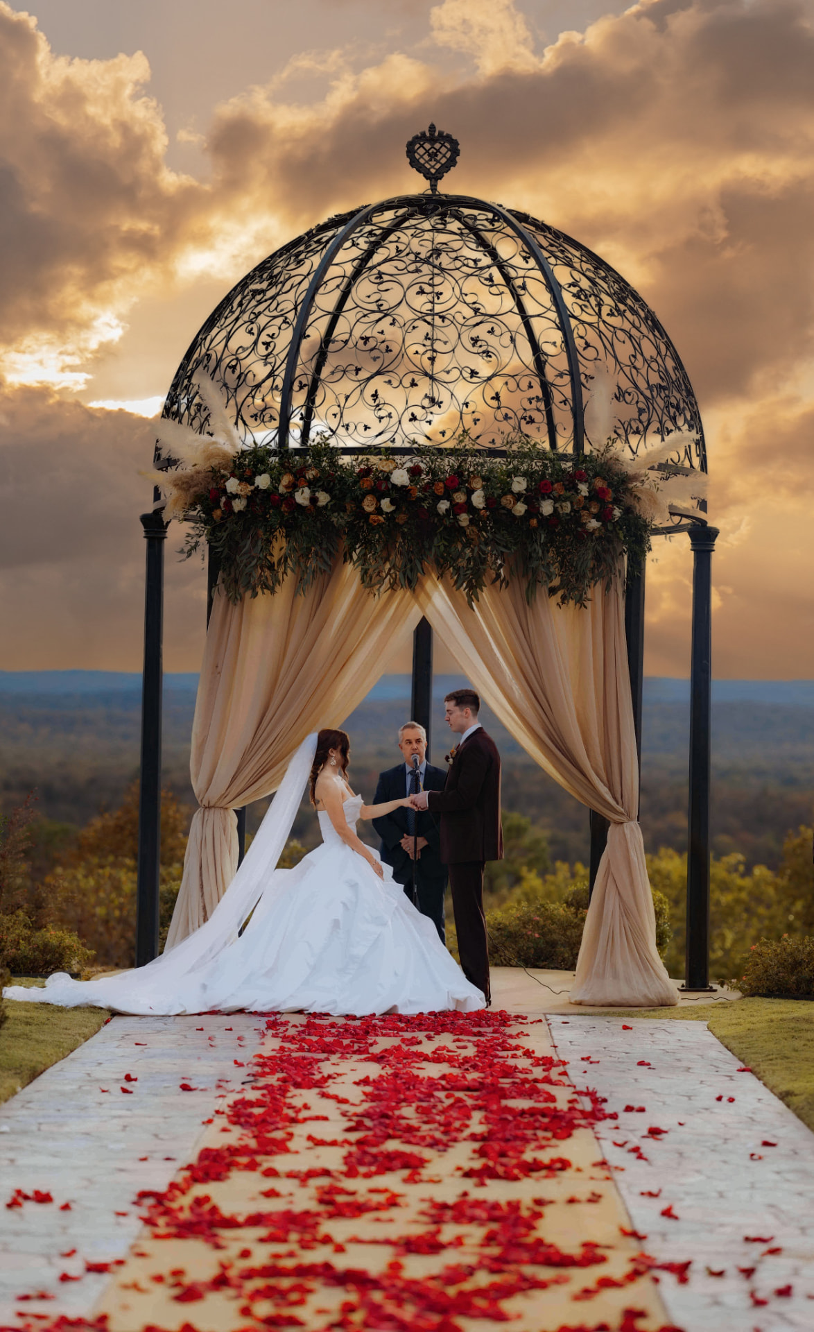 Wedding ceremony beneath an ornate gazebo at sunset